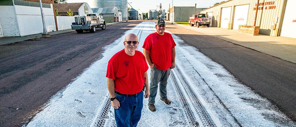 Two Lesterville Fire Department firefighters standing on a trail of foam